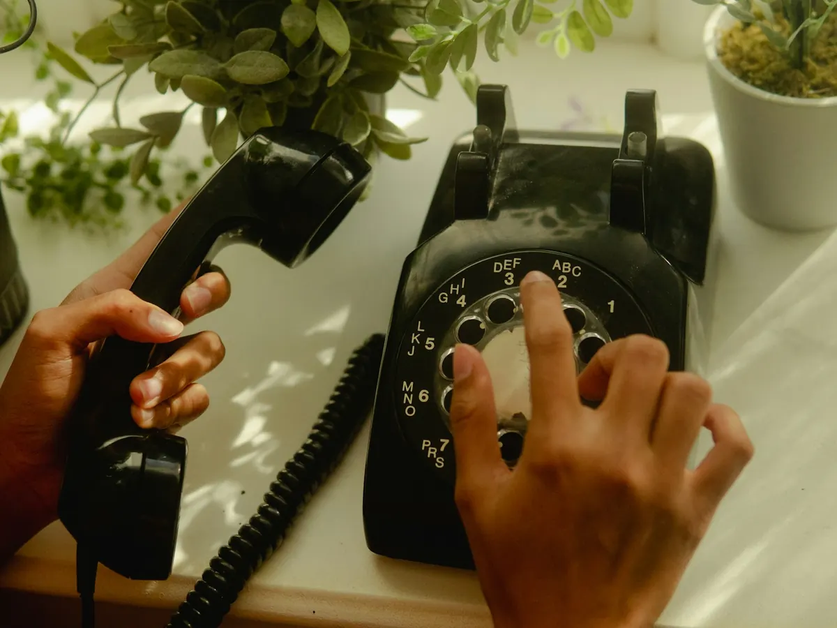 Hands dialing a rotary landline phone